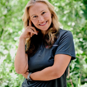 A woman in a black shirt poses confidently for a headshot photo, showcasing her style and personality.
